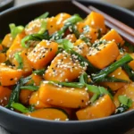 Vegan kabocha stir-fry with ginger, garlic, and green onions in a wok, served with steamed rice.